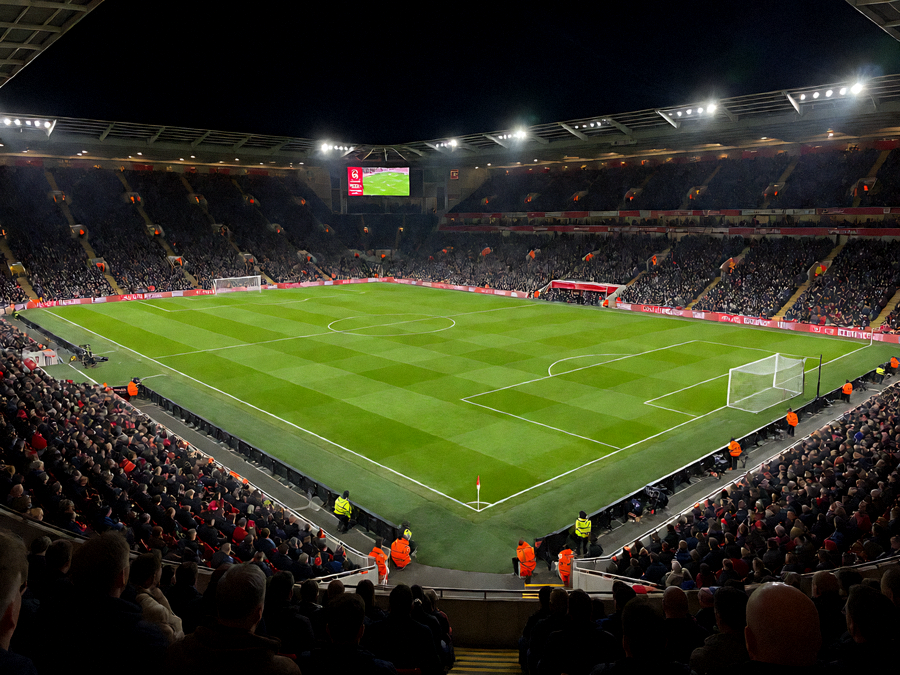 夜晚灯光下的足球场看台与绿茵场地全景